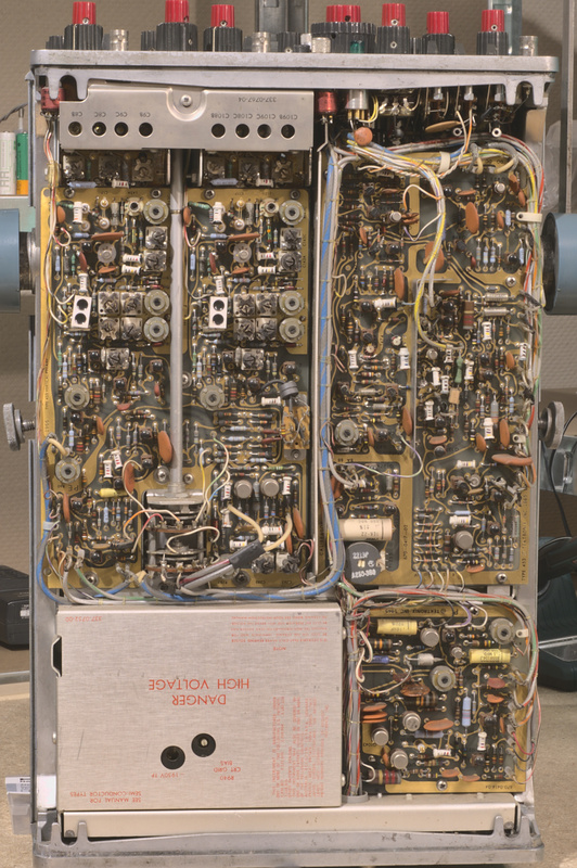 Bottom side view of the Tektronix type 453 analog oscilloscope with the top and bottom cover removed showing very tightly packed internal circuitry. The oscilloscope is standup upright.