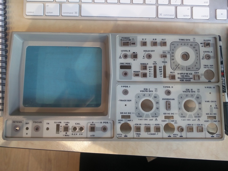 Image showing the now clean front panel of the Hameg HM1005 analog oscilloscope. This front panel is detached from the rest of the instrument laying flat on a table.