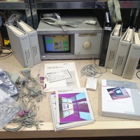 A display of the HP 16500B with most documentation and manuals as well as an attached mouse and probes.
